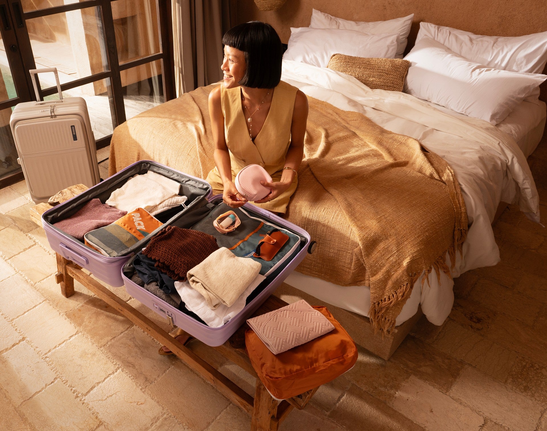 Woman packing a Tranto suitcase on a bed