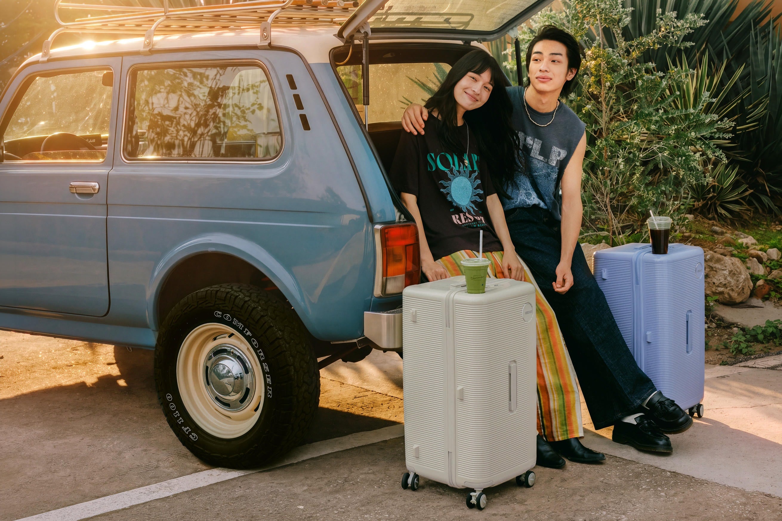Couple by a vintage van with luggage
