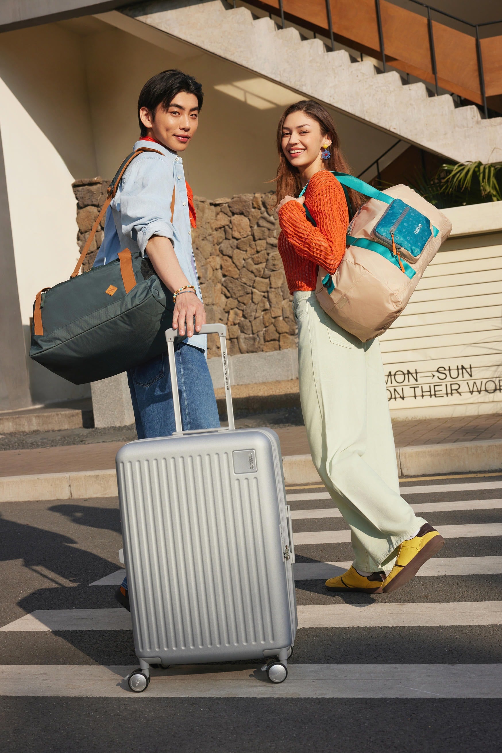 Two travellers walking with luggage in the hills